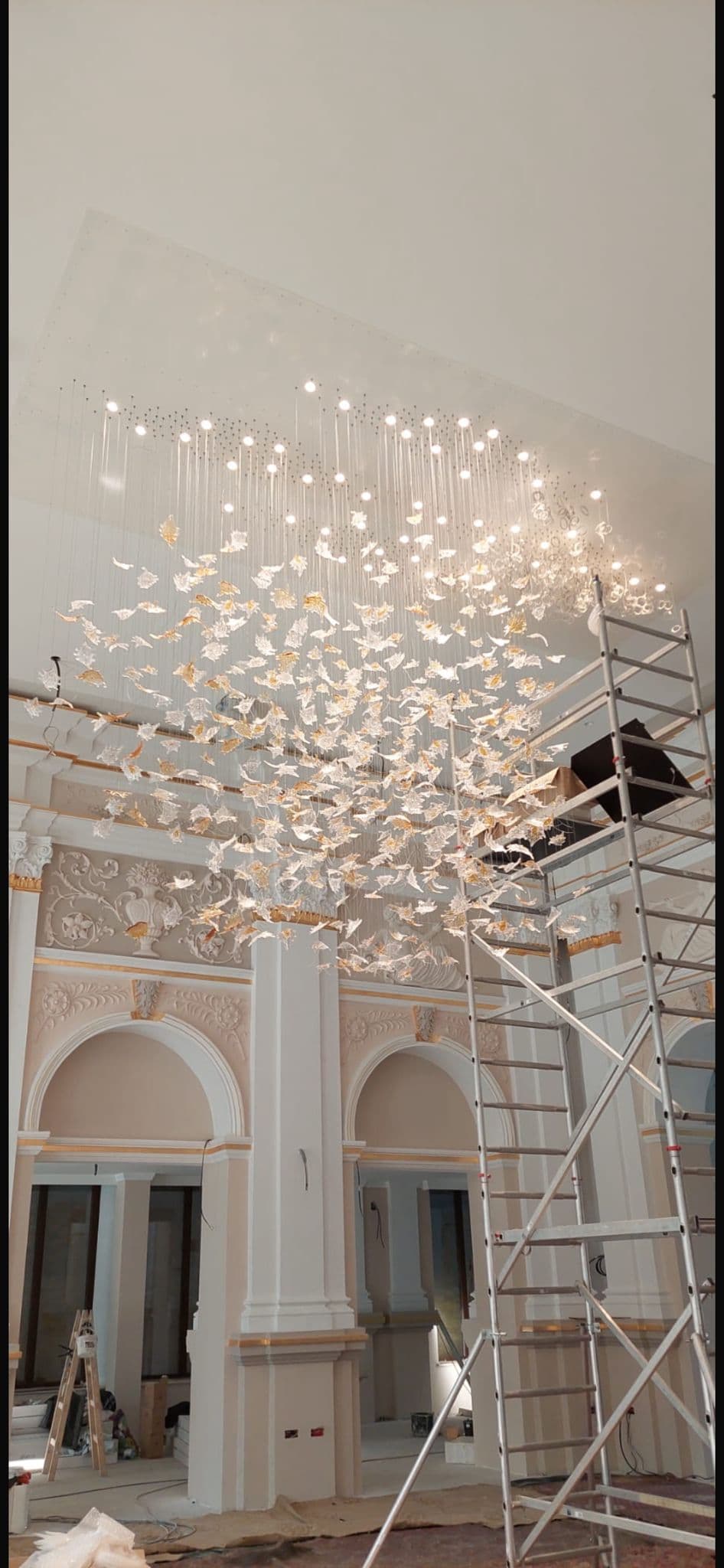 Candelabru decorativ instalat intr-un interior in lucru cu arcade si schela
